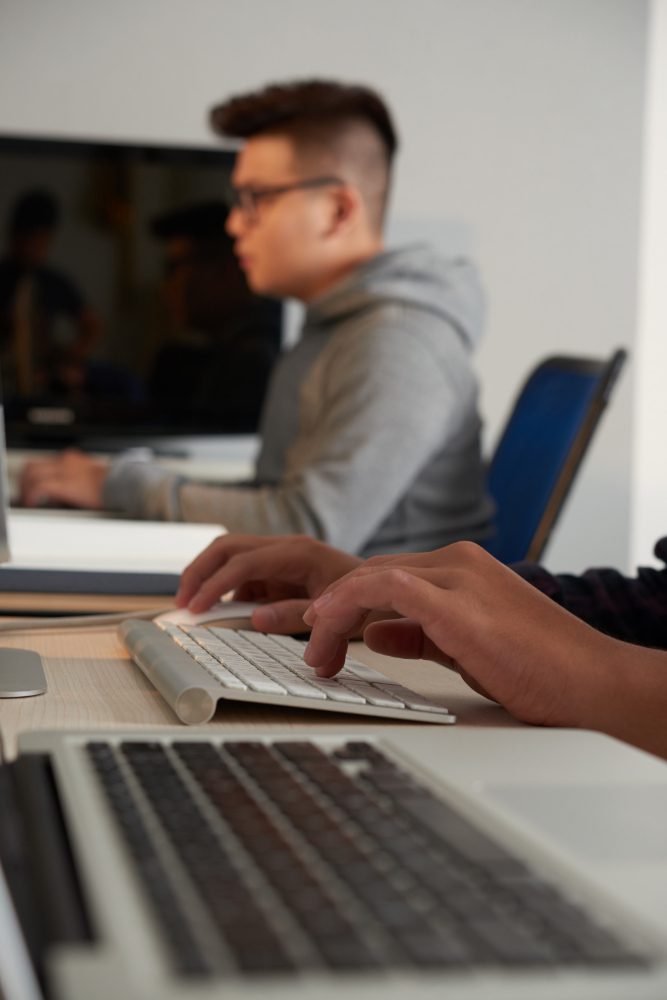 Website design - man typing at a keyboard in a shared workspace