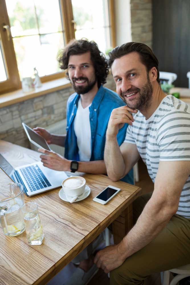 Website design - two men reviewing a tablet together at a table