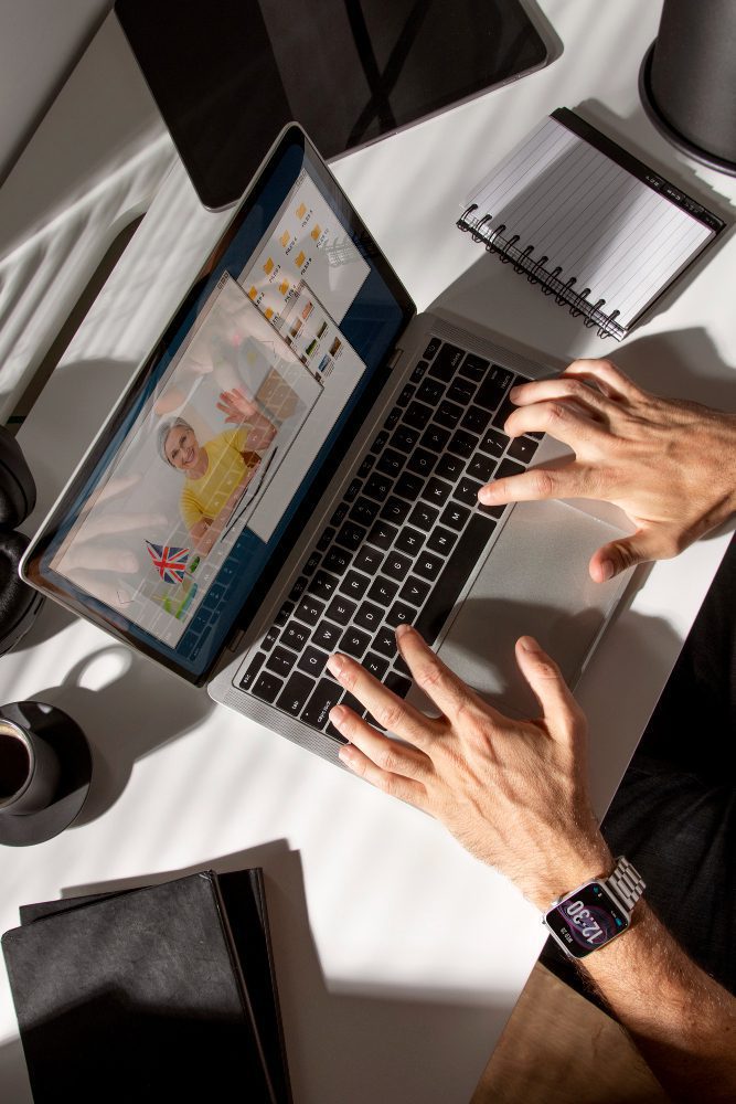 Website design - overhead view of hands typing on a laptop showing a colourful layout