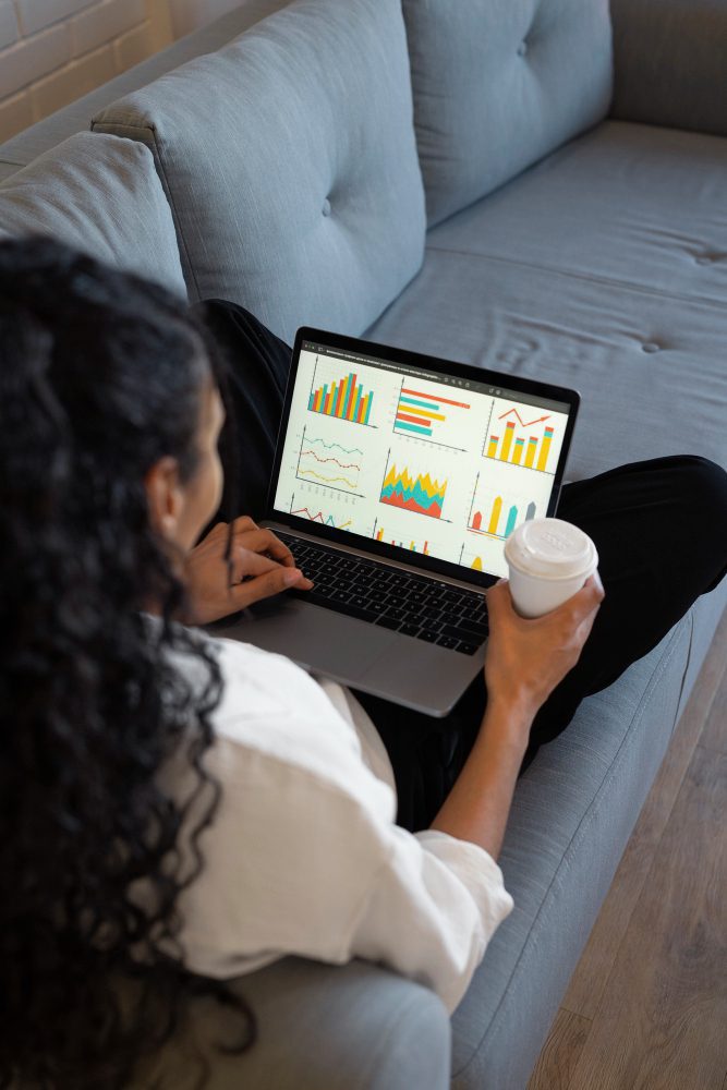 SEO - woman on a sofa reviewing charts on a laptop with a coffee
