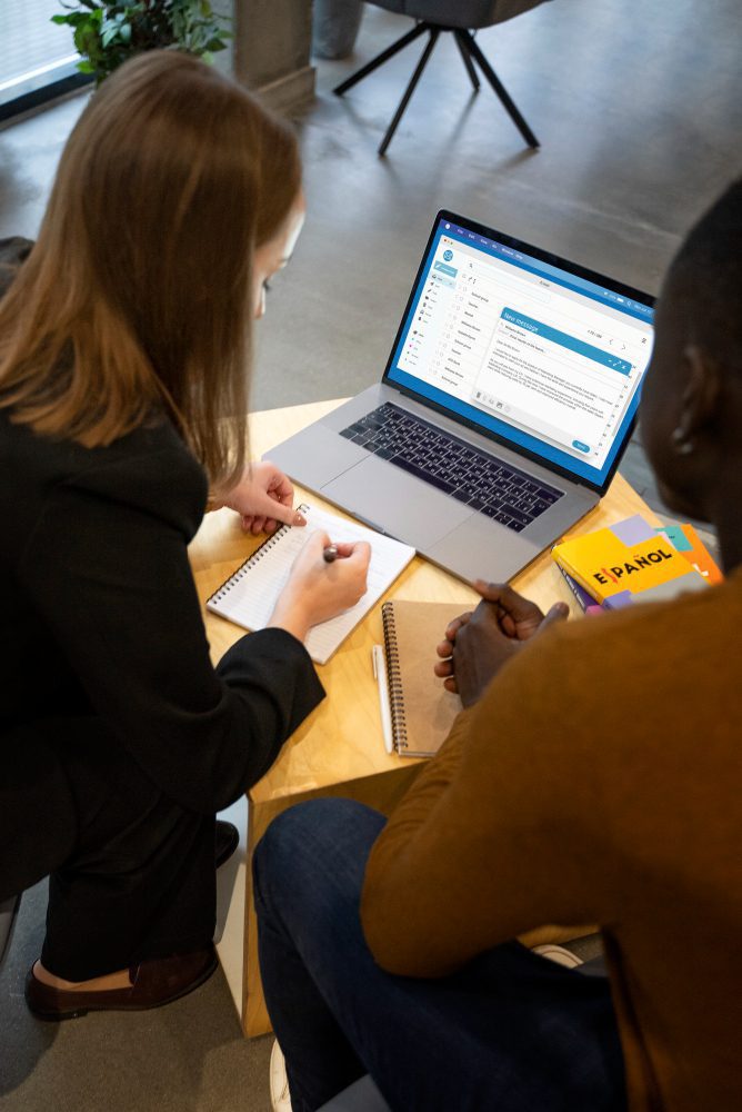 Website design - two colleagues working through notes beside a laptop
