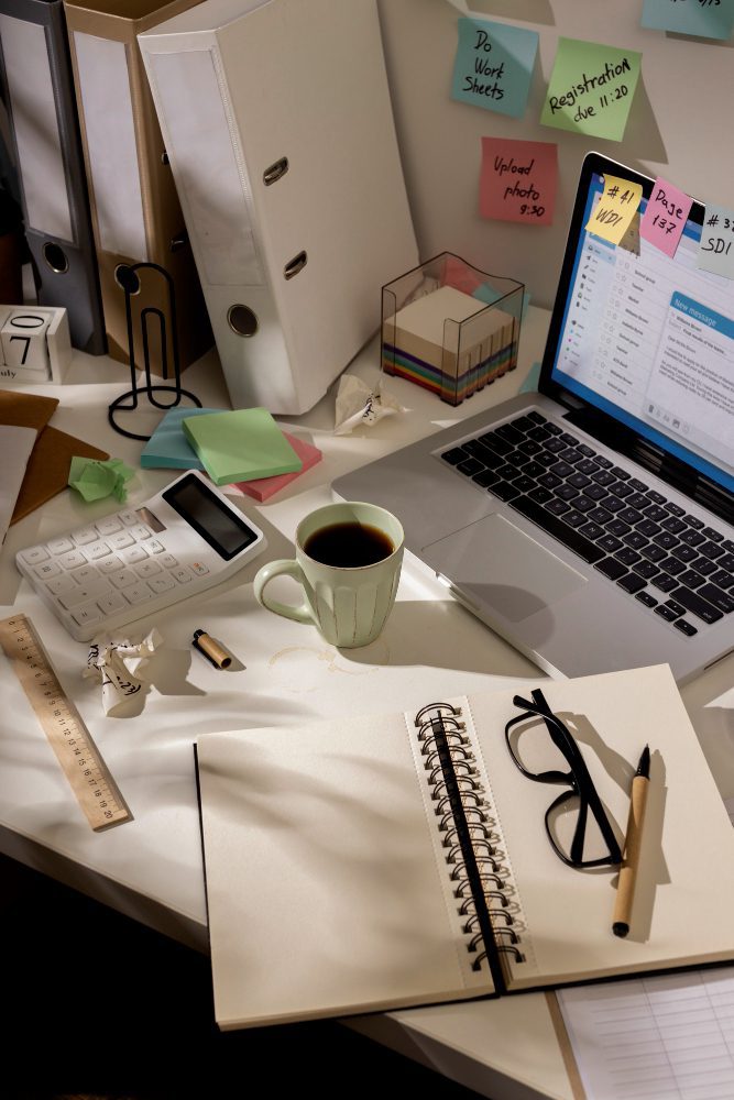 Website design - desk with a laptop, coffee, notebook and glasses
