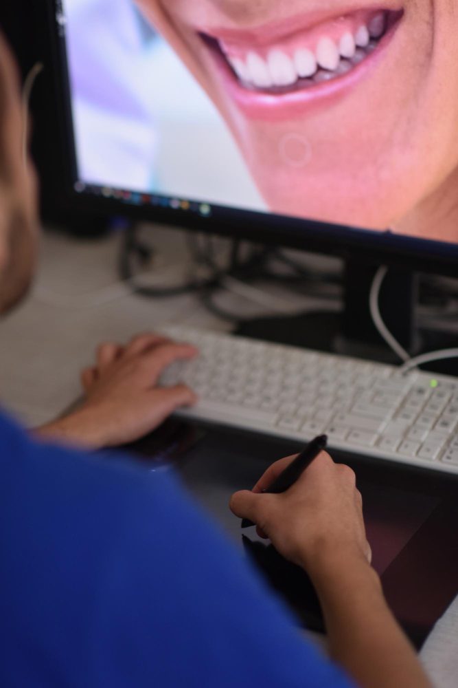 Dental website design in Newcastle - a dentist reviewing a patient smile on a practice screen