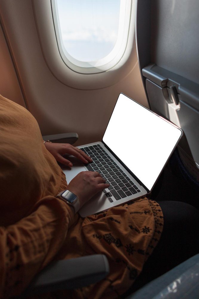 Website design for Newcastle Australia - a passenger working on a laptop beside an aeroplane window