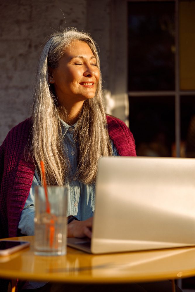 Website design - woman working at a laptop in warm evening light
