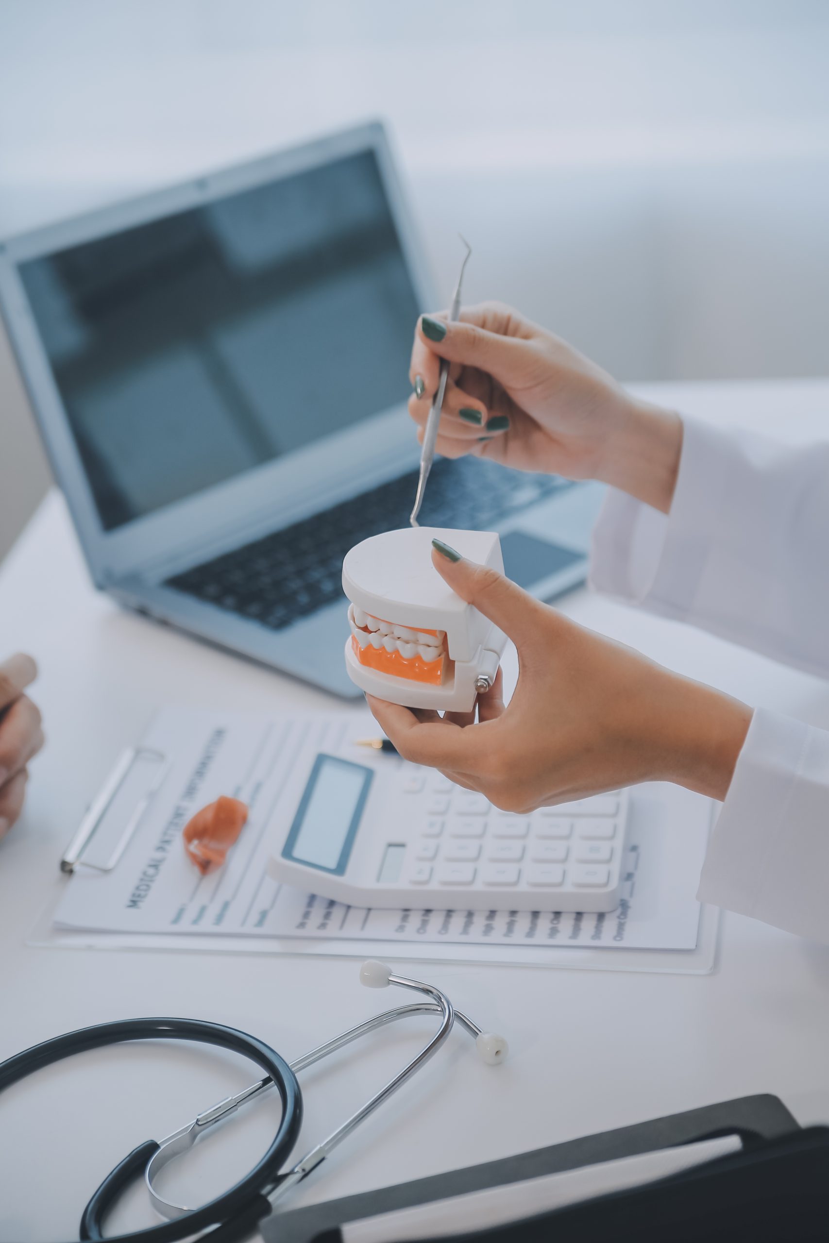 Dental website design in Newcastle - hands holding a sample pot at a desk with a stethoscope