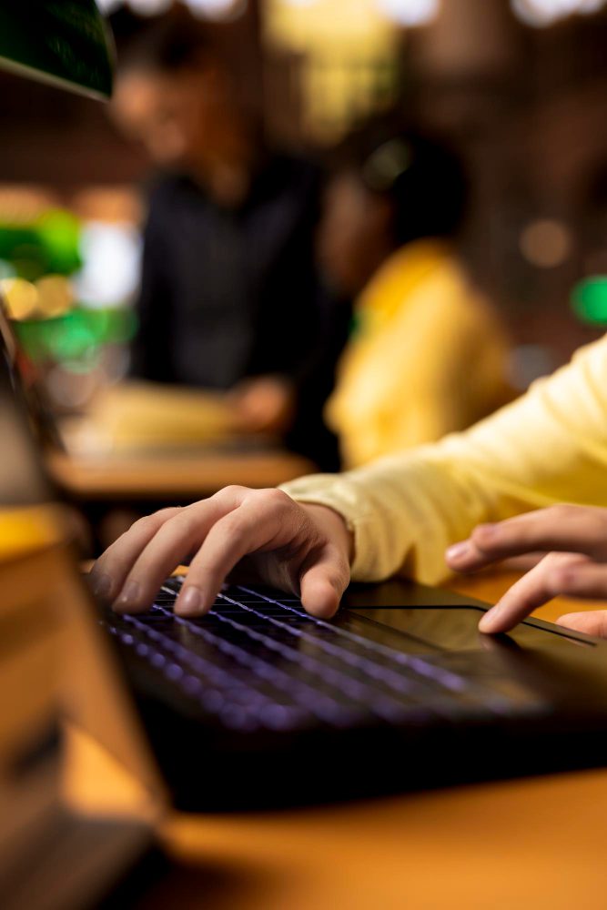 Website design in Abbey Meads, Swindon - typing on a laptop keyboard in a warmly lit workspace