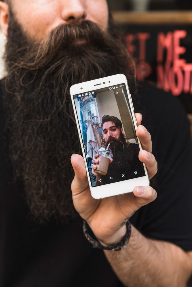 Website design - man holding a phone playing a video of himself