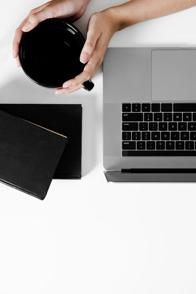Website design - overhead view of hands beside a laptop and notebook