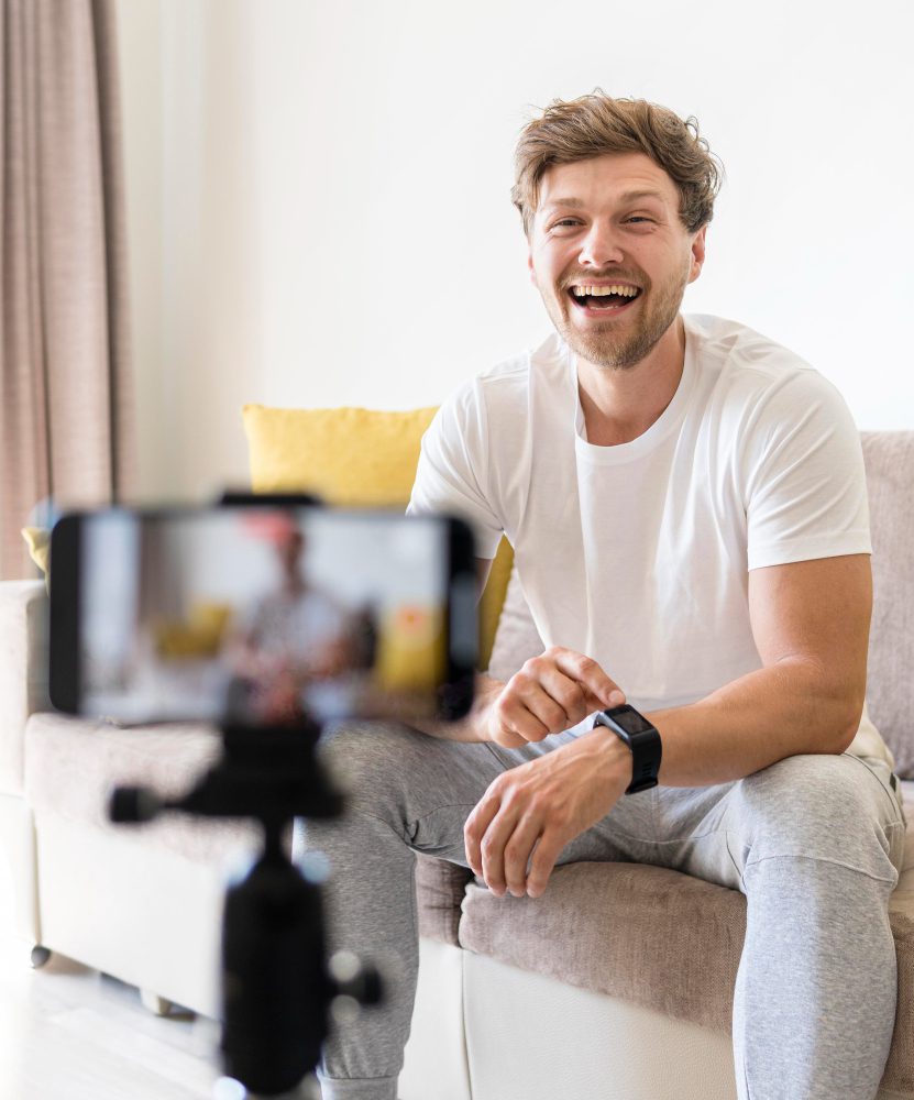 Social media - man laughing while recording a video on a phone