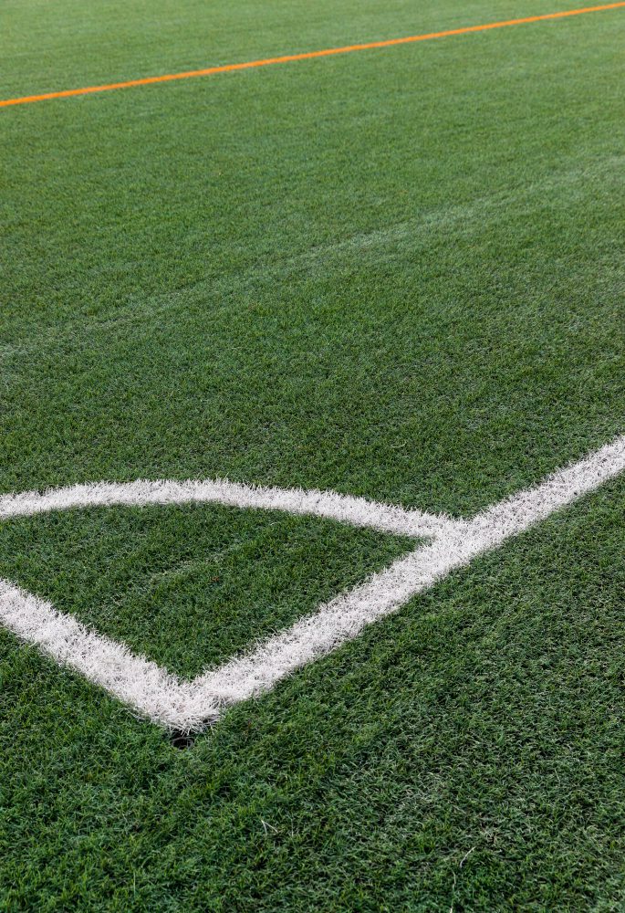 Website design - white corner markings on the grass of a football pitch
