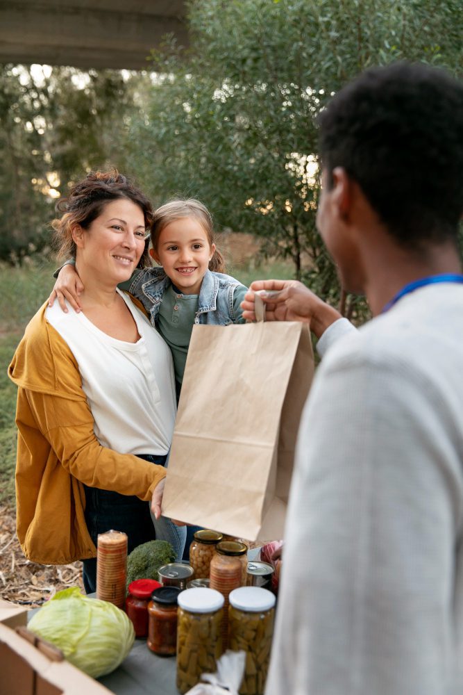 Website design - family collecting a paper bag of food at a community project