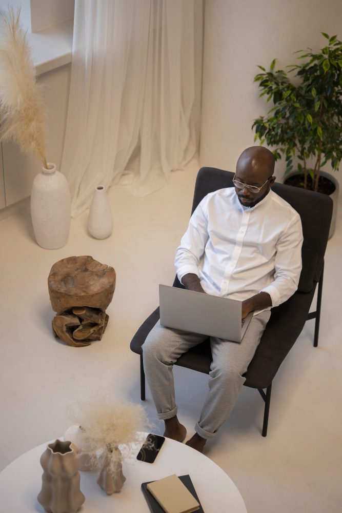 Website design - man working on a laptop in a calm, minimally furnished room