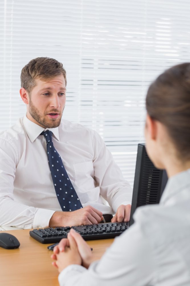 Website design - man in a shirt and tie talking to a colleague at a desk