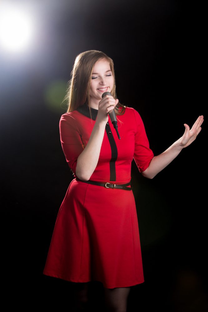 Social media - singer in a red dress performing under a spotlight