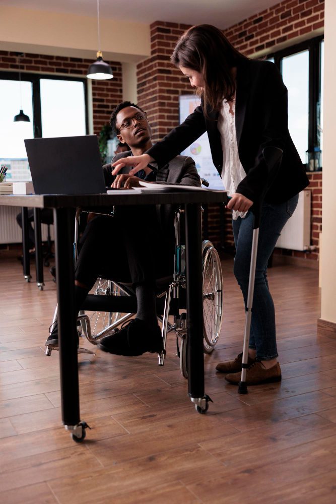 Website design - two colleagues at an accessible height-adjustable desk