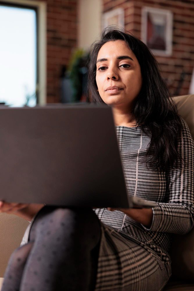 Website design - woman working on a laptop in a brick-walled studio