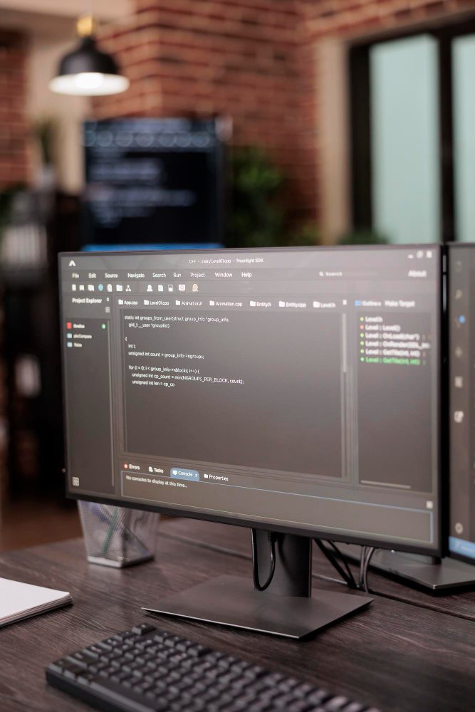Website design - desktop monitor showing a code editor on a wooden desk