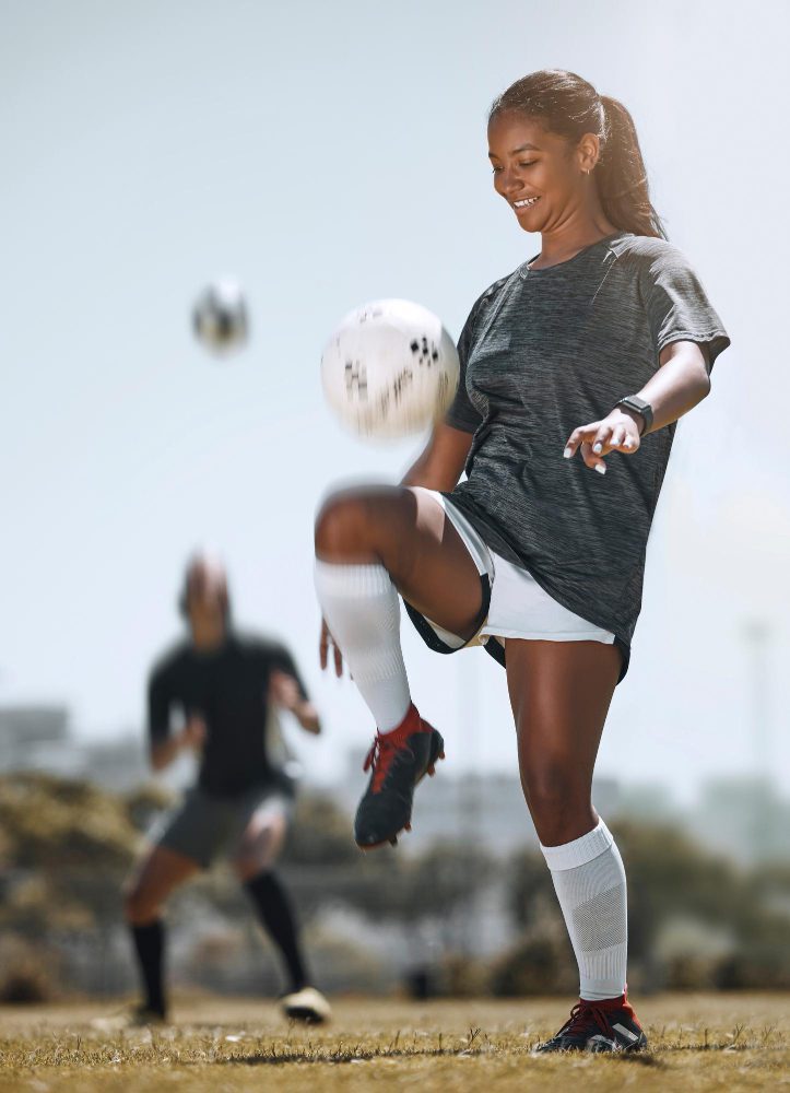 Website design - footballer practising keepy-uppies on the pitch