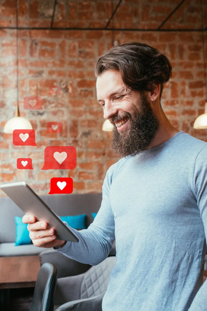 Man using a tablet with social media heart icons floating
