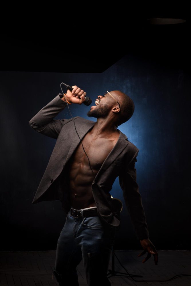 Social media - man singing into a microphone on a dark stage
