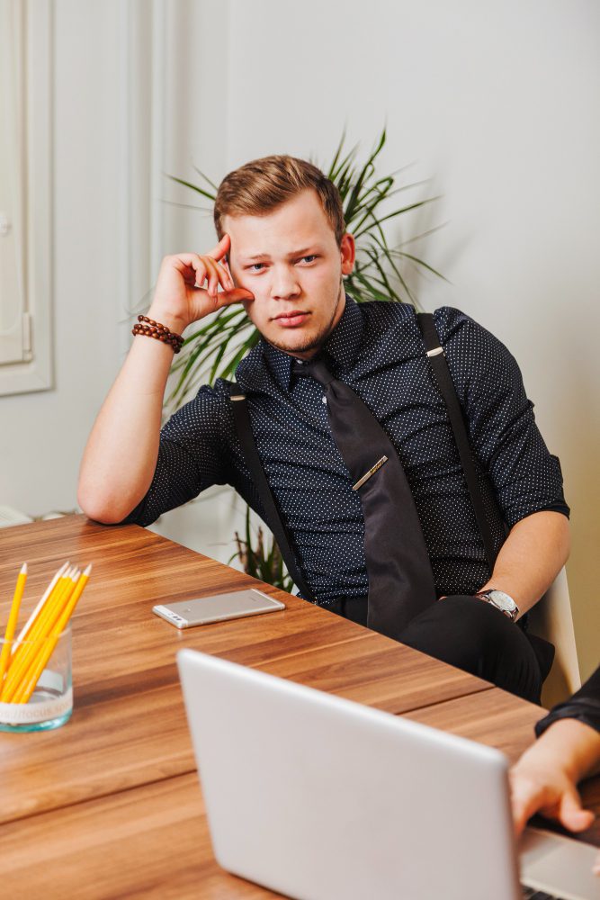Website design - man pausing to think at his laptop