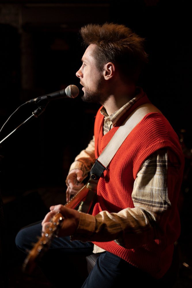 Social media - musician singing and playing guitar on stage