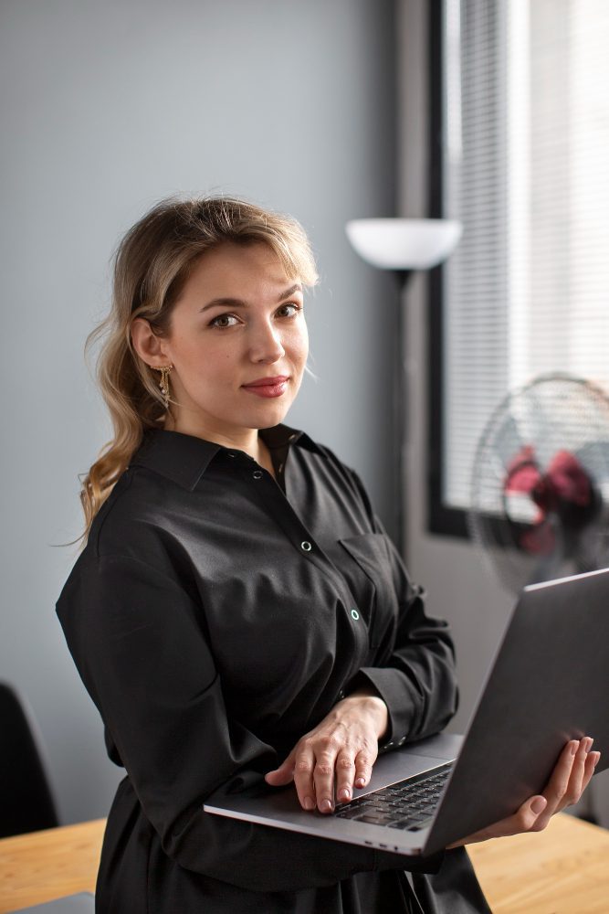 Website design - woman holding an open laptop in an office