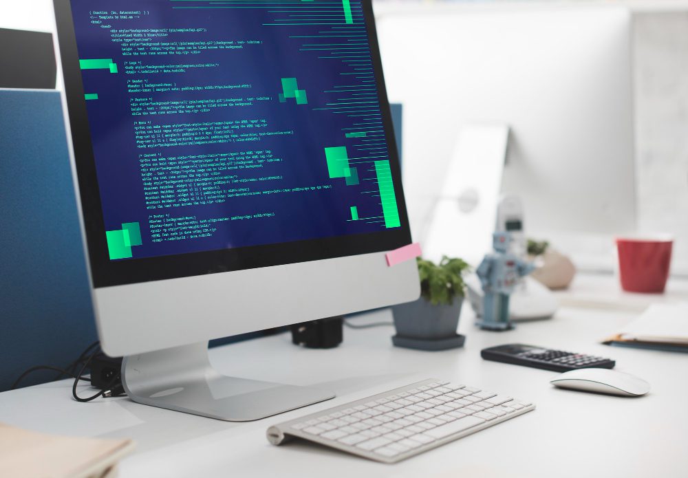 Website design - desktop computer showing code in a bright studio