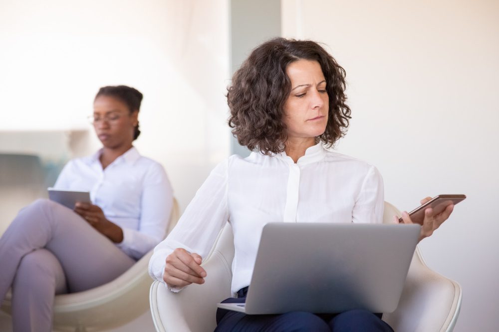 Website design - two women in a consultation, one taking notes on a laptop