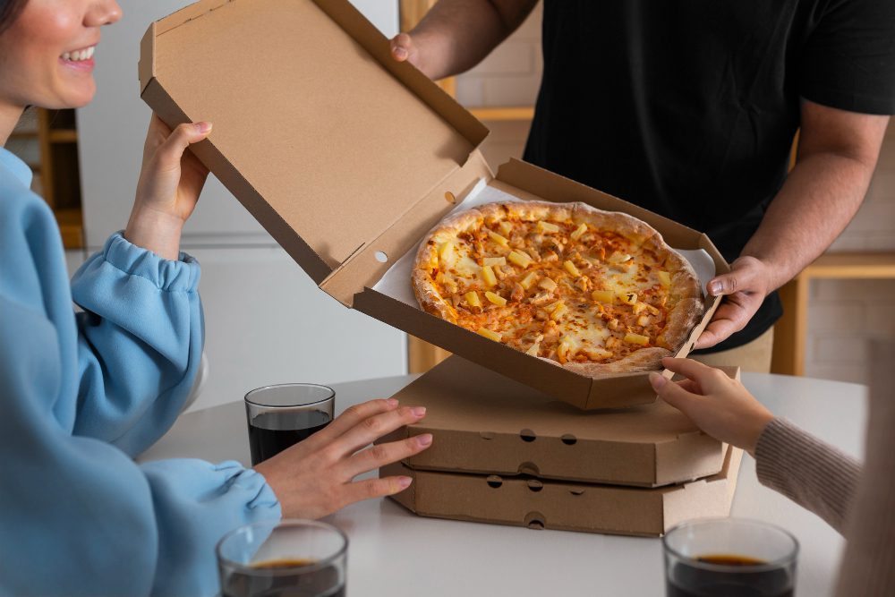 Website design - friends opening a pizza box at a table
