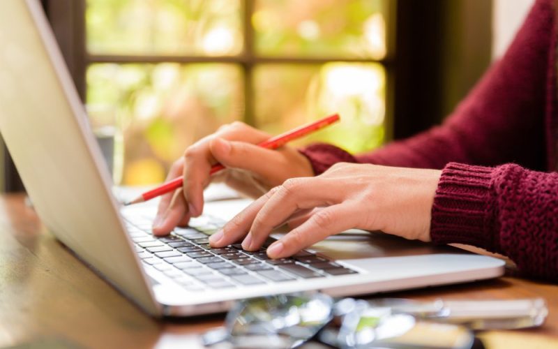 Website design - hands typing on a laptop by a sunlit window