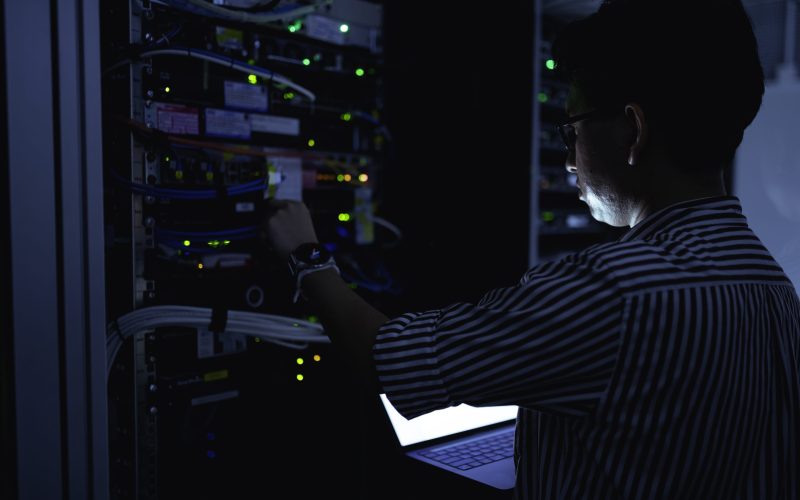 Web hosting - engineer maintaining server hardware in a dark data centre