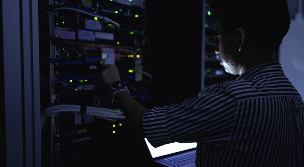 Computer engineer is setting up network in server room,Systems Maintenance Technician,Male engineer working in server room at modern data center