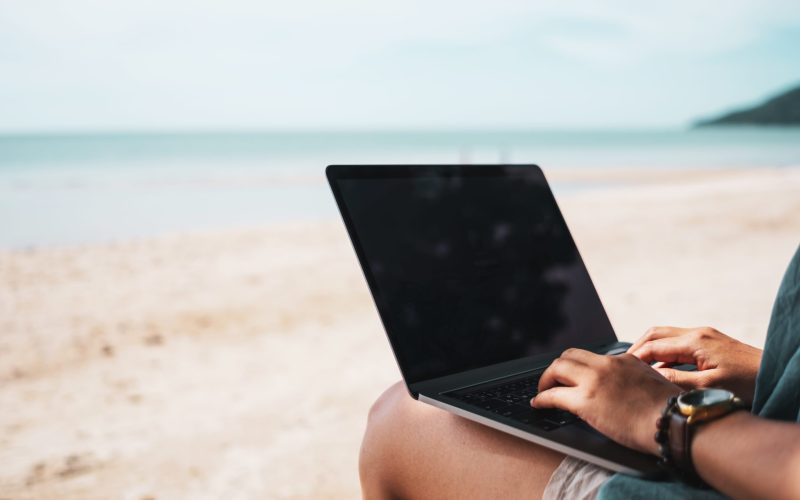 Woman using laptop and smartphone to work study in vacation cady at beach background. Business, financial, trade stock maket and social network concept.